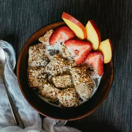 Bowl of Shredded Wheat Honey and Nut with Strawberries and Apple