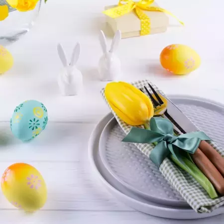 Easter breakfast table with yellow tulips and decorative eggs